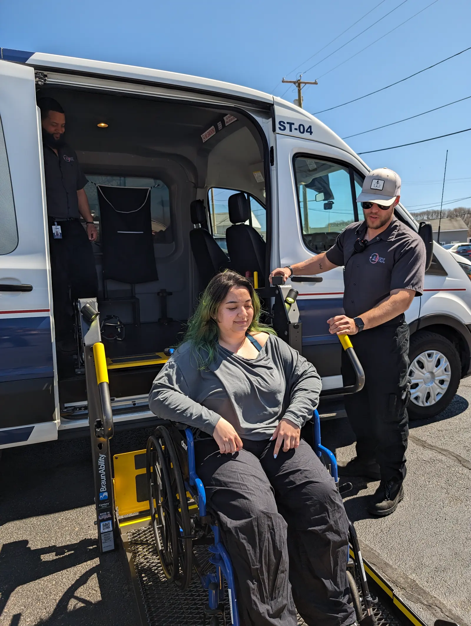 A rider in a wheelchair rides the lift into an Apex wheelchair van